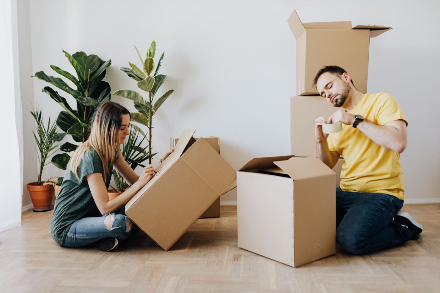 Couple packing and labeling moving boxes